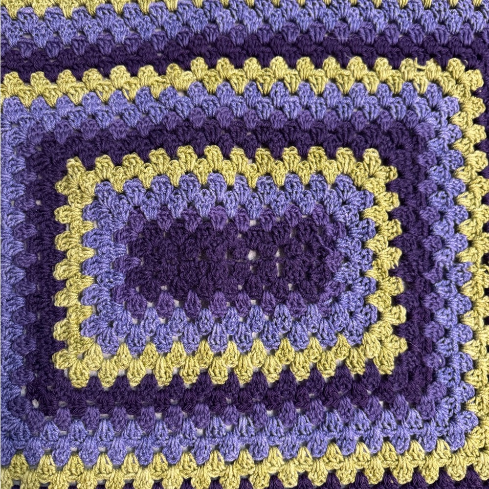 Vibrant hand crochet blanket.  33”x 32”olive green plum and purple yarn.